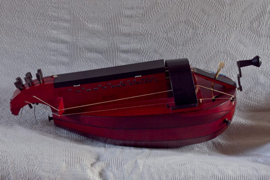 Ghironda a cassa di liuto, vista laterale su tessuto chiaro